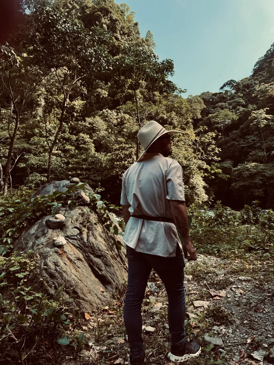 Jhonatan con sombrero en un sendero rodeado de bosque