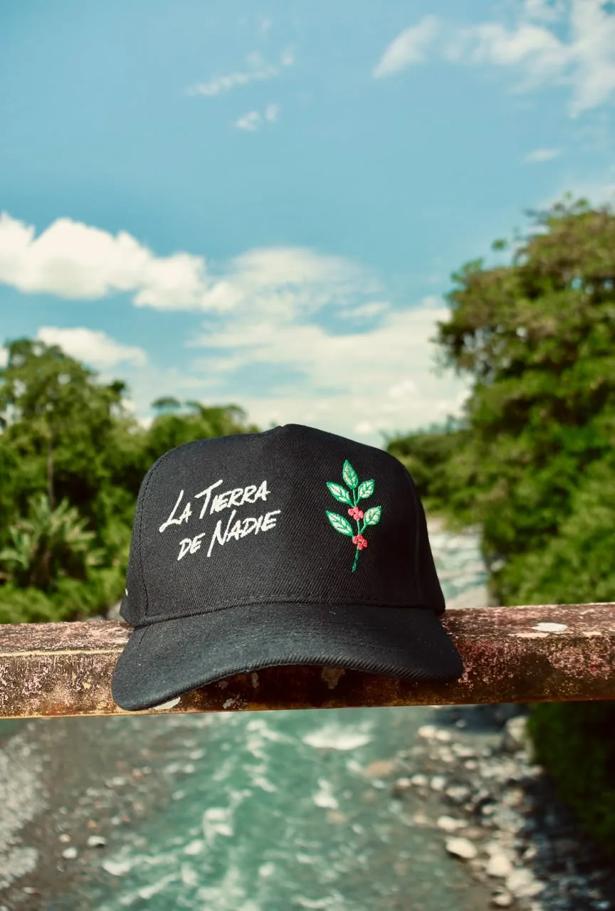 Gorra negra La Tierra de Nadie vista de frente junto al río